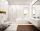 Modern white bathroom with wooden floor and white lightning below the bath