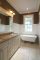 brown painted bathroom with white wainscot and crown molding