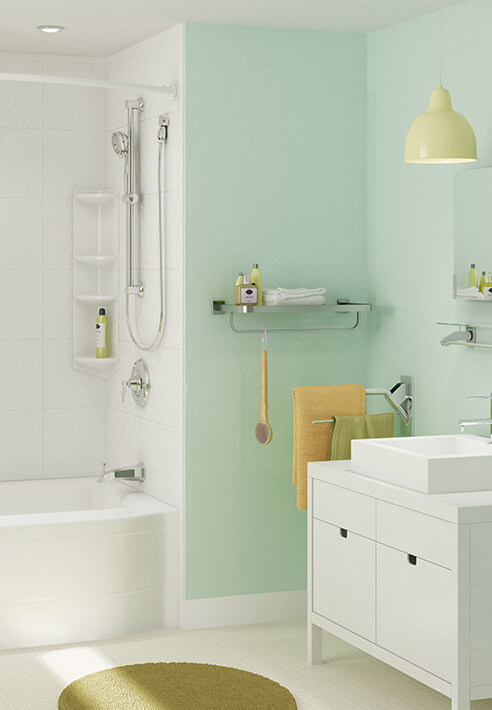 A white tub is surrounded by mint green bathroom walls