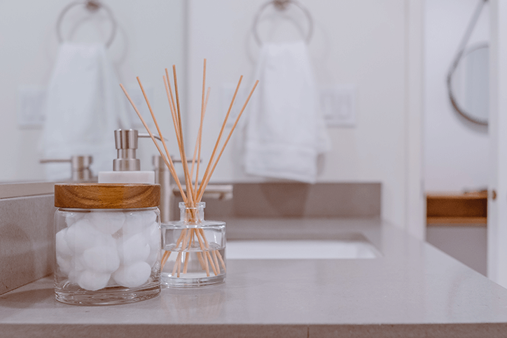 A clear glass jar sits on top of a sink vanity.