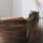 A woman lays with her back towards the camera in a wooden tub in a modern bathroom