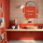 A burnt orange colored bathroom with a clay sink and a rounded mirror